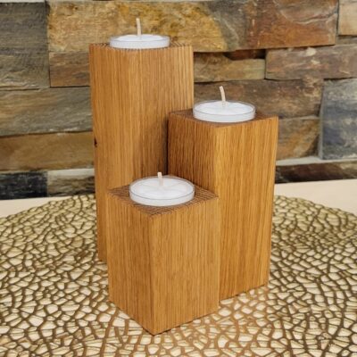 Three tealight candle holders made from solid oak rectangles of different sizes. A tealight sits in placement holes on the tops.