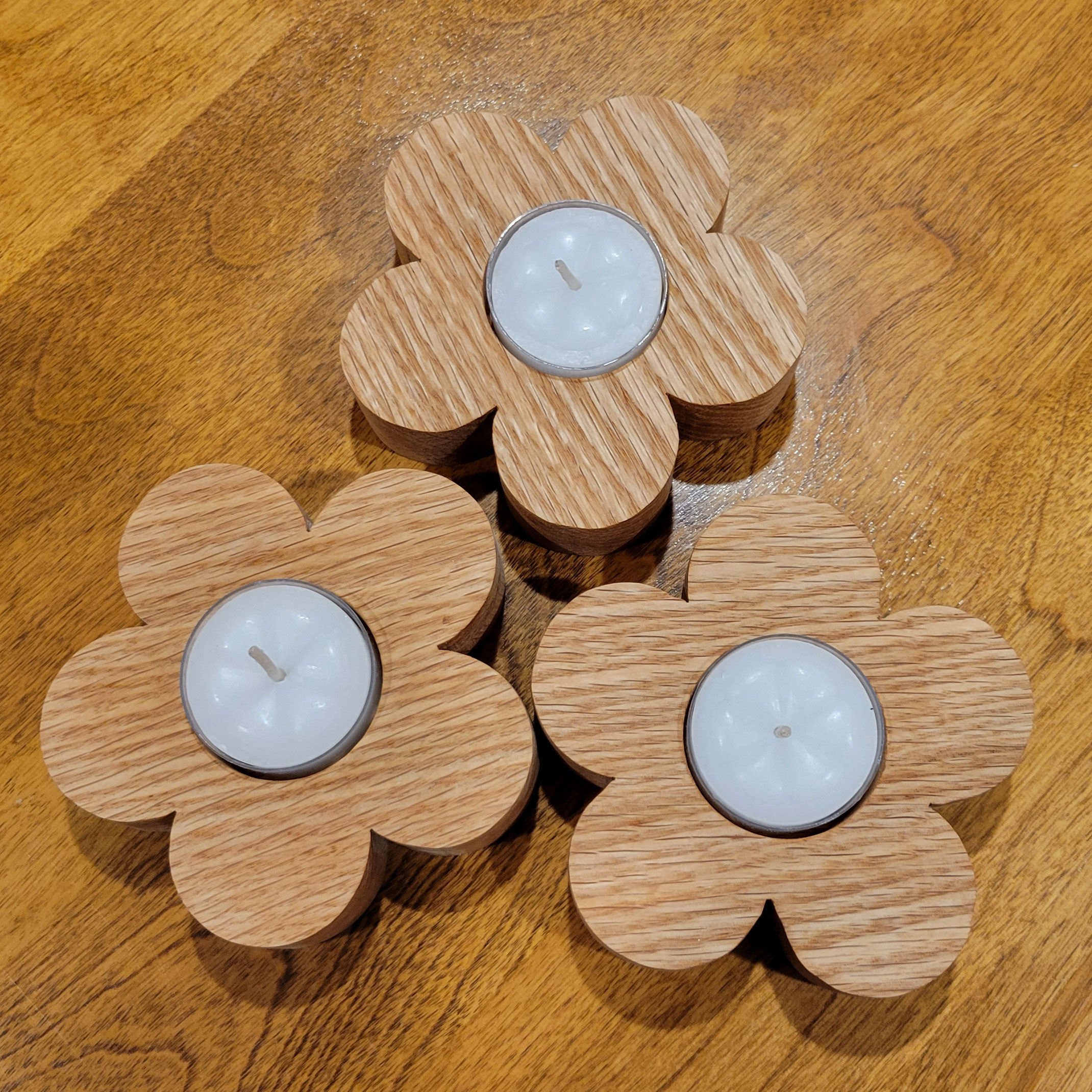 three flower petal shaped wood tealight holders.