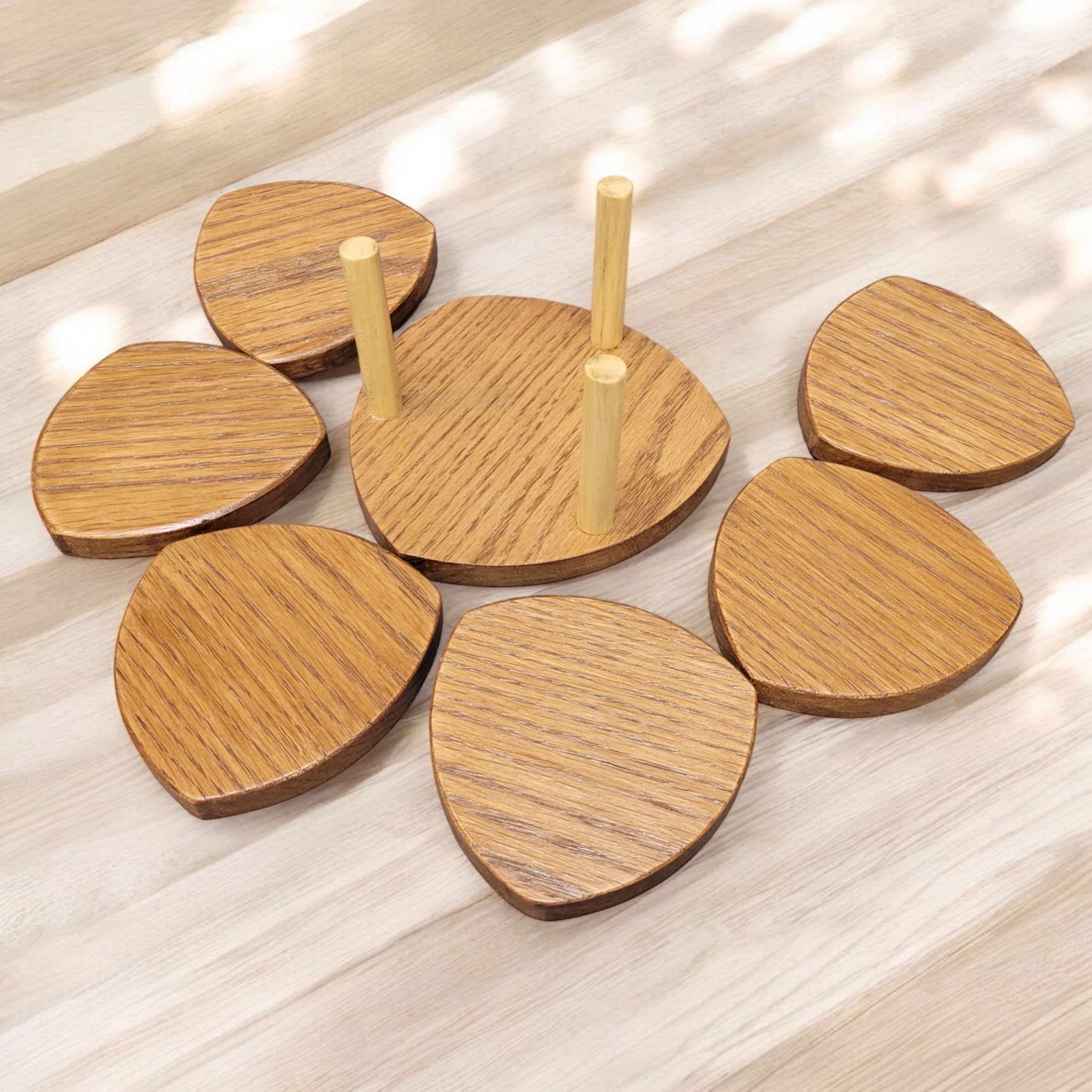 Six wood, shield shaped coasters on a table, with a holder.