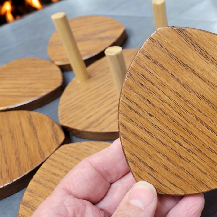 Six solid oak coasters with a holder sitting on a table top.