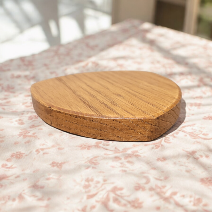 Six solid oak coasters with a holder sitting on a table top.