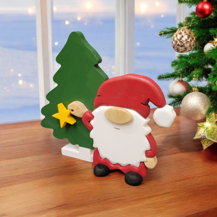 Christmas gnome with while beard, red hat, holding a yellow star, standing in front of a tall green tree.