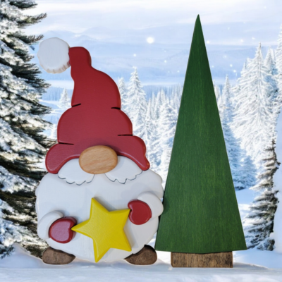 Christmas gnome with while beard, red hat and gloves, holding a yellow star, standing in front of a tall green tree.