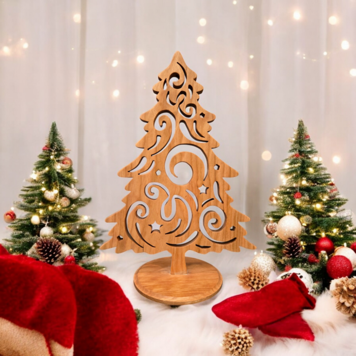 A delicate and intricately cut christmas tree sits on a table. The tree has curves and swirls cut into it, giving it a look of swirling wind.