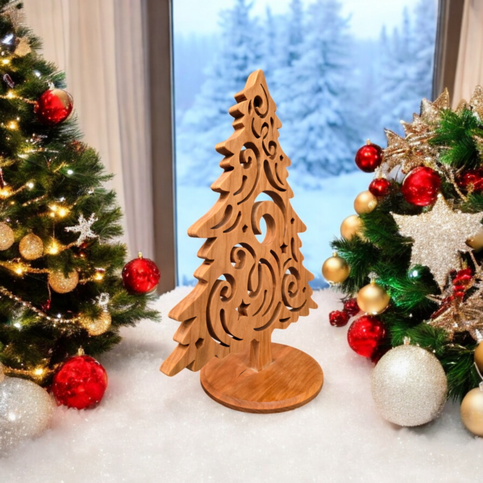 A delicate and intricately cut christmas tree sits on a table. The tree has curves and swirls cut into it, giving it a look of swirling wind.