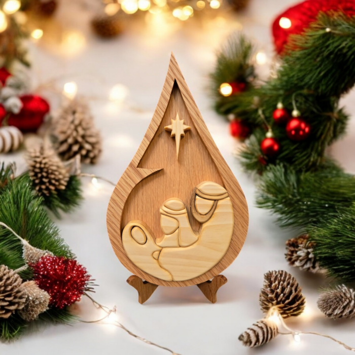 A christmas scene of ornaments and lights, with a wood teardrop shaped centerpiece depicting the Holy Family under the Star.