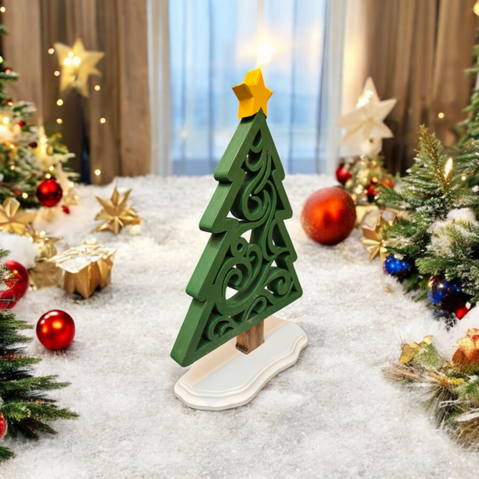 A delicate, ornamental wood tree, with a simple triangle-like outline and intricate swirl cuts on the inside. The tree stands on a white base with a yellow star on top.