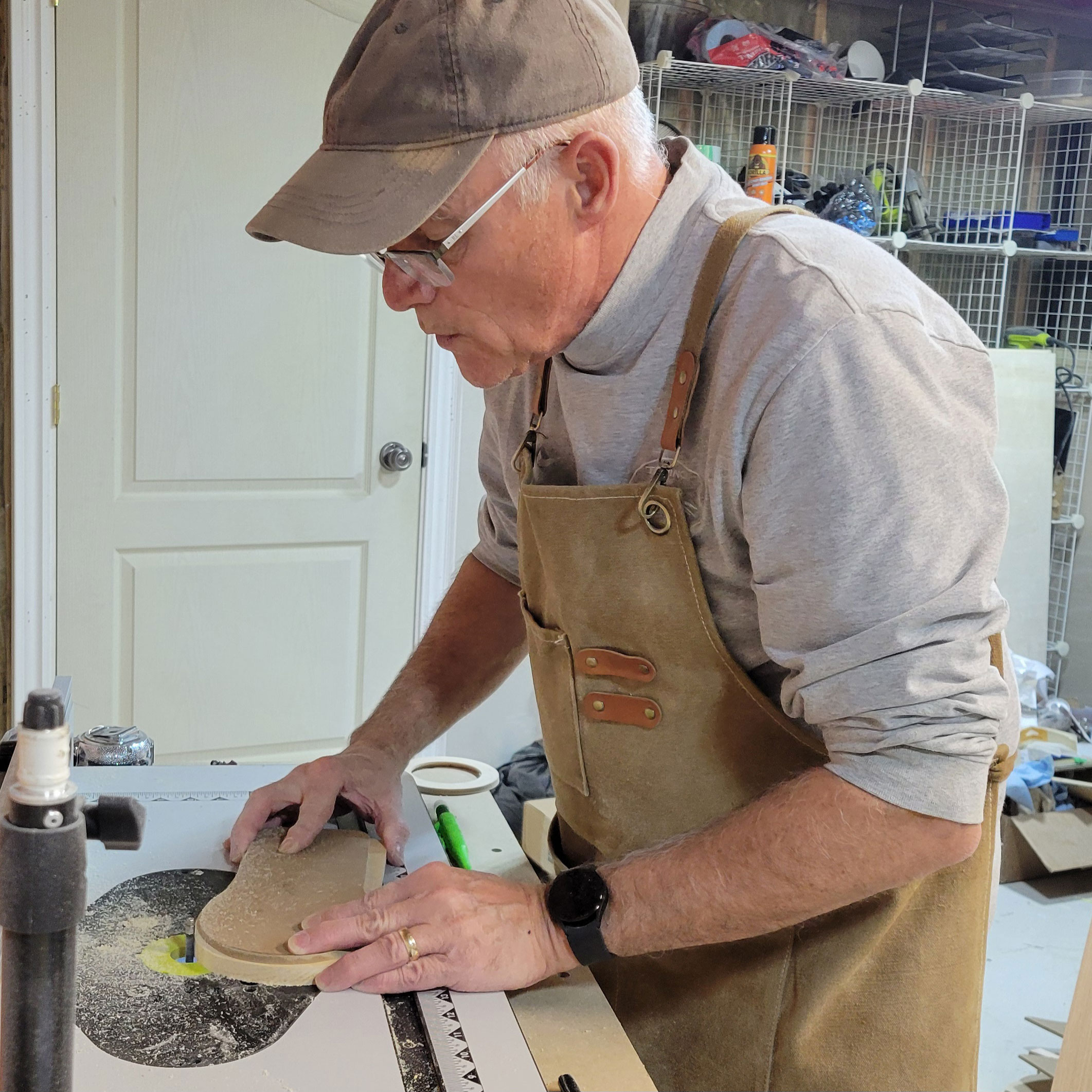 Maker cutting a shape on a router table.