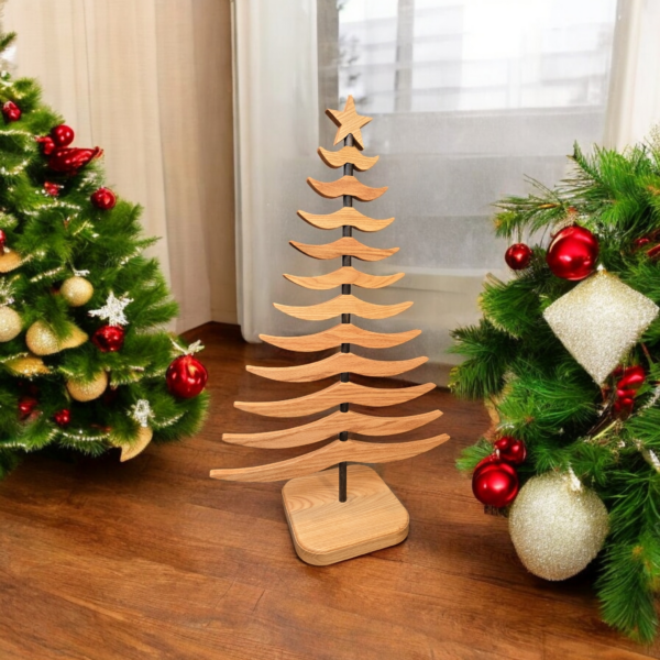 Wooden tree sitting on wood floor, with green, decorated Christmas trees on each side.