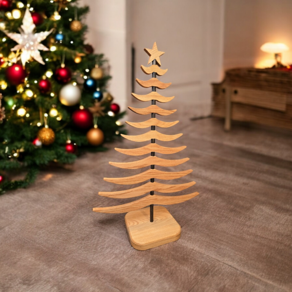 Wooden tree sitting on a floor in front of a Christmas tree and fireplace.