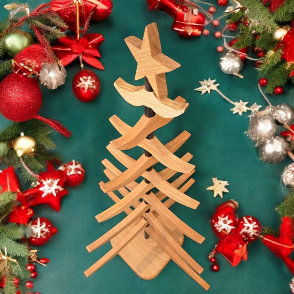 Looking down on a wooden tree sitting on a green fabric, surrounded by Christmas decorations.