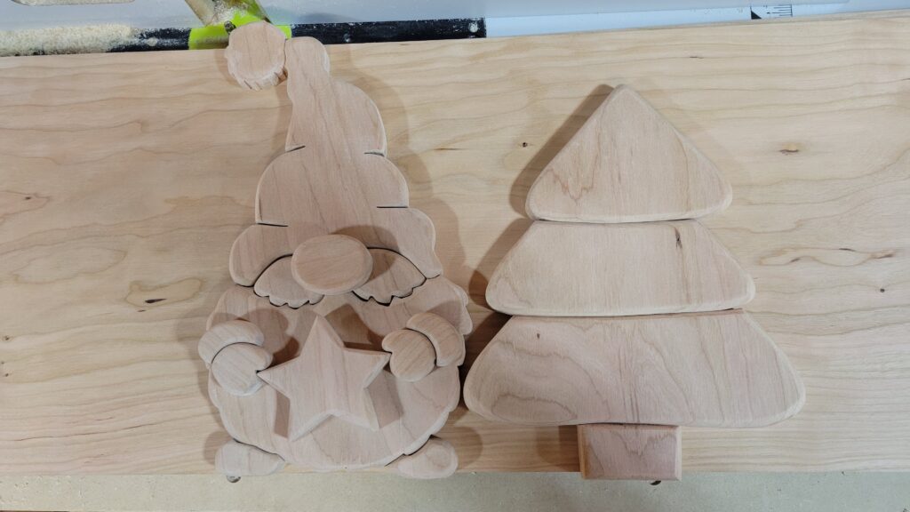 A wood gnome and tree lay on a table, ready for paint and assembly.