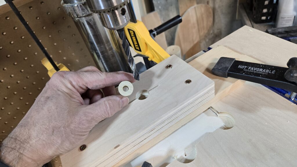 Photo of a drill that just cut a hole in the centre of a piece of wood dowel.