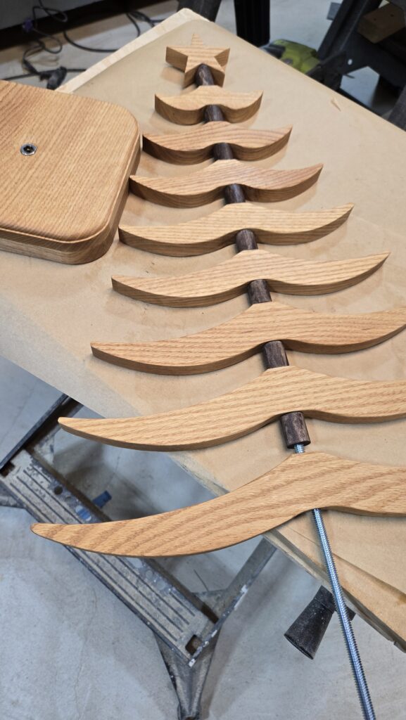 The branches of a wooden tree lying on the workbench, nearly assembled.